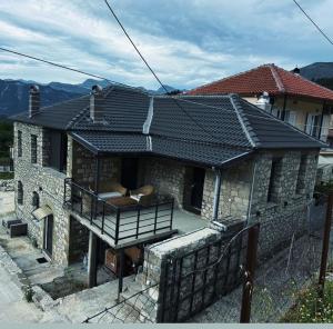 a house with a roof that has a balcony at Vasiliki Pramanta villas in Pramanta