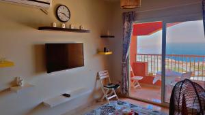 a living room with a flat screen tv and a balcony at Chalet in Porto Sokhna Hanging Gardens - Fifth Terrace Sea View شاليه في بورتو السخنة - الحدائق المعلقة - المصطبة الخامسة - إطلالة بحر مباشر in Ain Sokhna