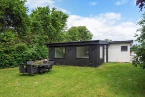 a black house with a table and chairs in a yard at S754-Stroby-Ladeplads-Svalemosevej-84 in Strøby Ladeplads