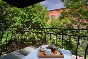 a table with a tea set on a balcony at Elysium Gallery Hotel in Yerevan