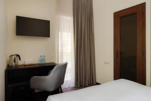 a hotel room with a bed and a desk with a chair at Elysium Gallery Hotel in Yerevan