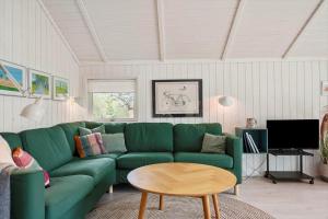 a living room with a green couch and a table at 3064-Stege-Maegleren-34 in Stege