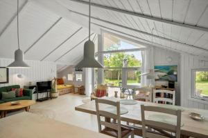 a dining room and living room with a table and chairs at 3064-Stege-Maegleren-34 in Stege +12 photos