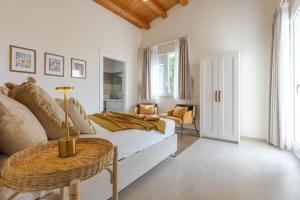 a white bedroom with a bed and a table at Villa Lumiere in Modica +22 photos