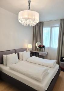 a bedroom with two beds and a chandelier at SOLE DI DIANA LUXURY Apartments in Peschiera del Garda +42 photos