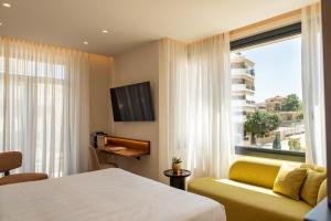 a hotel room with a bed and a window at Aetheria Boutique Hotel & Spa in Markopoulo