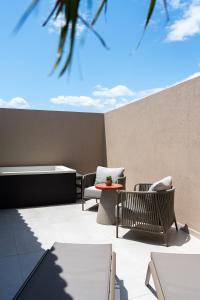 a patio with two chairs and a table and aermottermott at Aetheria Boutique Hotel & Spa in Markopoulo