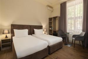 a hotel room with a bed and a desk at Elysium Gallery Hotel in Yerevan