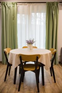 a table with chairs and a vase of flowers on it at My Home Apartments in Berehove +16 photos