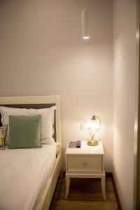 a bedroom with a bed and a nightstand with a lamp at My Home Apartments in Berehove
