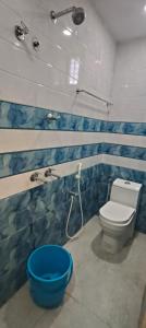 a bathroom with a toilet and a blue bowl at RVS Residency in Kāyalpattinam