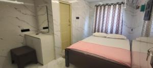 a small bedroom with a bed and a mirror at RVS Residency in Kāyalpattinam