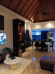 a living room with a table and a dining room at Baan Thai Surin Garden in Surin Beach