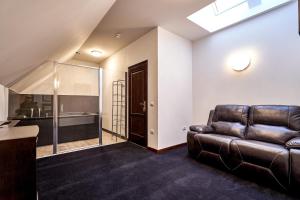 a living room with a leather couch and a bathroom at PENSIUNE RESTAURANT CAPRA NEAGRA in Moisei