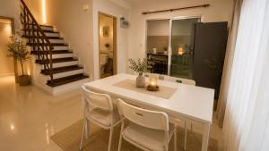 a dining room with a white table and chairs at City Hill Residence in Ban Khok Chang