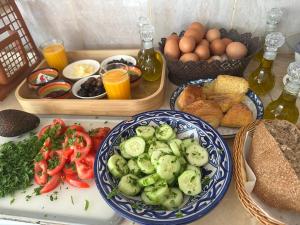a table with plates of vegetables and eggs and bread at Dar Bleu Pearl in Chefchaouen