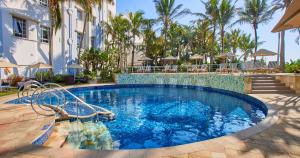 a pool at a resort with palm trees at Suncoast Hotel & Towers in Durban