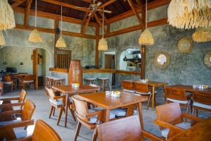 a dining room with wooden tables and chairs at Bi Bi Bliss Ubud Villa in Ubud