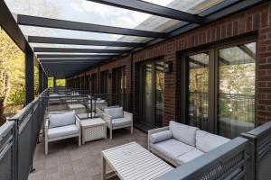 eine Terrasse mit Sofas und Stühlen auf einem Balkon in der Unterkunft Hotel Traugutta3 in Białystok