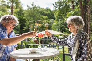 two older women sitting at a table with glasses of wine at Villa Siesta, Park & Pool Living in Losone +46 photos