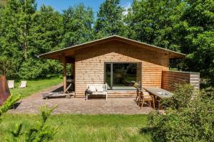 a small cabin with a patio in the grass at 2314-Stege-Ulvshale-Cedervej-4-B in Tyrholm