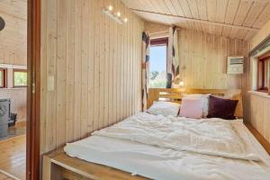 a bed in a room with a wooden wall at 8256-Vordingborg-Kastaniegardsvej-4 in Vordingborg