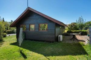 a small house with a table in a yard at 8256-Vordingborg-Kastaniegardsvej-4 in Vordingborg