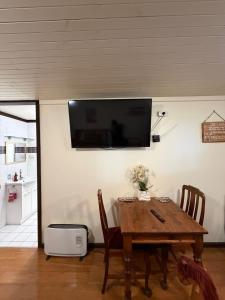 a dining room with a table and a television on the wall at Avoca Park Equestrian Farmstay in Macclesfield