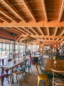 an empty restaurant with wooden tables and chairs at Lodges en Provence - Ecogîtes & Restaurant insolites in Richerenches +48 photos