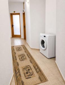a washing machine in a room with a rug at Къща за гости Уют in Sveti Vlas