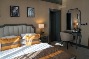 a bedroom with a bed and a desk and a mirror at Crixus Hotels Sarsing in Sarsing