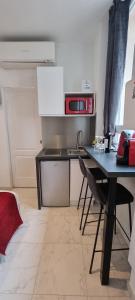 a kitchen with a black table and a microwave at Sweet Home Marceau - 6 studios hyper centre proche de la mer et du palais in Cannes