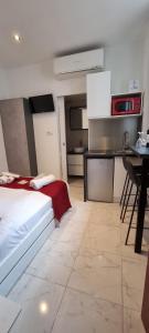 a bedroom with a bed and a kitchen with a table at Sweet Home Marceau - 6 studios hyper centre proche de la mer et du palais in Cannes