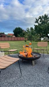 two chairs and a fire pit in a park at Wolf House in Balatonboglár