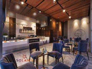 a restaurant with blue chairs and tables and a counter at Solaris in Christiansborg