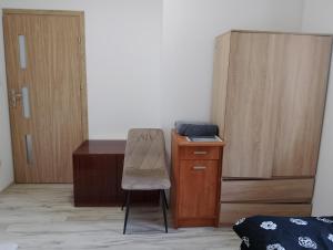 a chair in a room with a desk and a table at Pod Lasem in Altanka