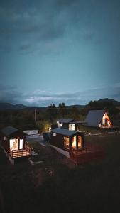 a couple of small houses sitting in a field at SkyAtlas Hideaway in Sohodol