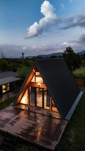 a small house with a black roof on a deck at SkyAtlas Hideaway in Sohodol
