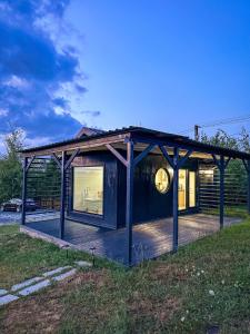 a house with a deck with a clock on it at SkyAtlas Hideaway in Sohodol