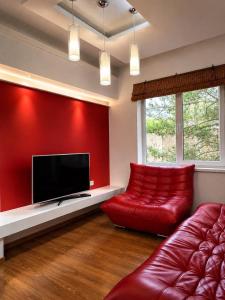 a living room with a red wall and a red couch at Sunny House Seaside in Zatoka