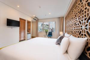a bedroom with a large white bed and a window at Gemini Saigon LUXURY in Ho Chi Minh City