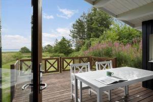 a porch with a white table and chairs on a deck at OH456-Storvorde-Kystvej-173 in Storvorde