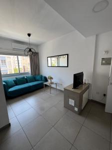 a living room with a blue couch and a tv at Anastasia 1 Bedroom Apartment in Limassol