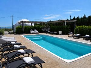 a swimming pool with chaise lounge chairs next to it at Maison du golf in Costinesti
