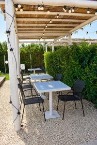 a group of tables and chairs under a pergola at Maison du golf in Costinesti