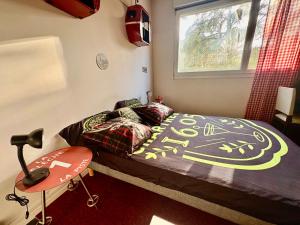 a bedroom with a bed and a table and a window at Studio lumineux et climatisé avec parking gratuit - Tramway devant la résidence - appartement 114 in Grenoble