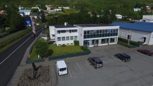 un edificio blanco con coches estacionados en un estacionamiento en Hotel Eskifjörður en Eskifjörður