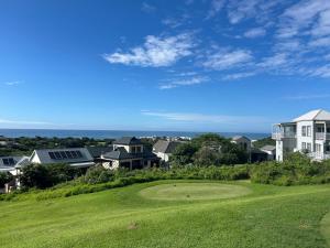 a view of a golf green with houses in the background at Beautiful Lagoon House in Blythedale