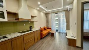 a kitchen with an orange couch in a room at Ruby's Home The Ruby Hạ Long in Ha Long