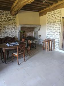 a room with a table and chairs and a fireplace at La Ferme du Mont in Foissy